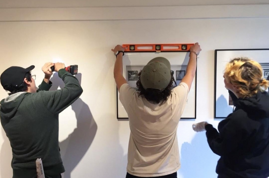 Sesnon Gallery interns and students installing an exhibition using levels and power tools