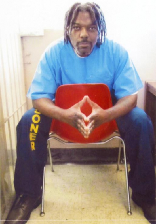 Timothy James Young is pictured sitting at a red chair with his hands clasped in front of him.